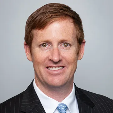 A man in suit and tie smiling for the camera.