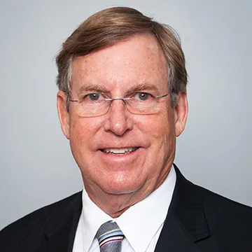 A man in suit and tie smiling for the camera.